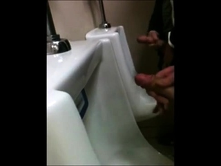 two slim dicks getting wanked at the urinals